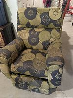 Full view of the Lazy Boy recliner chair with floral green and brown upholstery showing signs of heavy wear and discoloration.