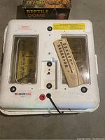 Top view of the Little Giant incubator with thermometer on top showing temperature scale, dual viewing windows, and caution labels.