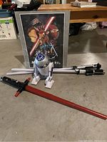 Lot contents showing 3 lightsabers (red, white/black, silver/black) and R2-D2 figurine positioned in front of Star Wars Disney style poster.