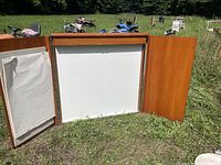 Front view of the teaching unit open showing whiteboard center, pull-down screen above, wooden side panels, and chart paper pad on left side.