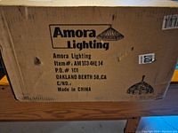 Box of chandelier labeled Amora Lighting, with item details and origin (Made in China).