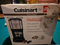 Front of the Cuisinart Buona Tazza espresso and coffee machine box showing product image and features such as 19 bars of pressure, espresso & coffee, stay-clean brew head, adjustable strength and temperature.