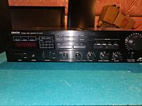 Front of the Denon DRA-55V receiver showing control knobs, preset station buttons, tuning dial, power, headphone jack, and speakers A/B selector.