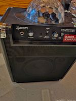 Front control panel with microphone input, volume and light mode knobs, Bluetooth button, and disco dome light on top.