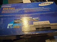 Top of the original Samsung DVD-P231 box showing product features and included remote control image.