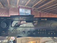 Front view of TEAC AG-D8900 receiver including control knobs, buttons, digital display, and part of remote on top.