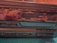 Close-up of the front panel showing the disc skip buttons, play controls, and group enter button of the disc changer.