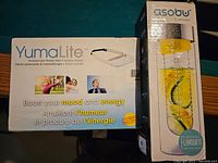 Box of YumaLite personal light therapy device showing front with text 'Boost your mood and energy' in English and French.
