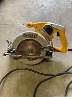 Side view of yellow DeWalt circular saw showing brand name, blade cover, handle, and cord
