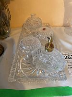 Photo of crystal glass tray holding two crystal trinket boxes and two crystal perfume bottles, showing detailed cut glass patterns and sizes