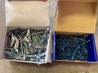 Open boxes showing metal screws and metal nail tool clips