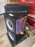 QSC USA400 amplifier on top of speaker box showing front panel and general condition.