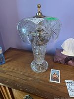 Full view of lamp showing cut glass base and globe top on wooden surface