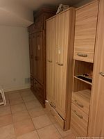 Full view of light wood wardrobe cabinet with two drawers, next to a darker wood cabinet.