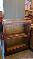 Front view of vintage wooden barrister bookcase with closed glass doors.