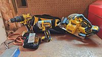 Overview of drill, impact driver, circular saw, batteries, charger and bag on wooden surface