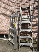 Both ladders side by side against brick wall