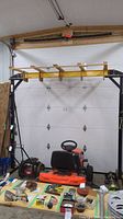 Full-frontal view of gantry crane showing A-frame legs, yellow beam, wooden frame, and base wheels.