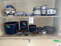 Shelf with assorted blue and white stoneware items including bowls, dishes, pots