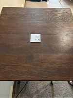 Top view of square wood tabletop showing wood grain and blemishes.