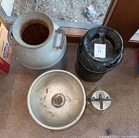 Top view showing aluminum milk jug, black metal jug with lid, cream separator bowl, and glass butter churn jar with hand crank.
