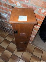 Top and angled side view showing the wooden CD tower with heart cutouts and metal handles against brick wall background.