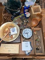 Overview showing various collectibles such as a vintage grinder, wooden wine glasses, agate stones, antique sprinkle lids, a wooden box, an alarm clock, and other items arranged on a table.