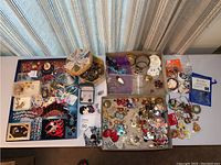 Full view of assorted costume jewelry including necklaces, brooches, earrings and bracelets spread on table with varied colors and styles.