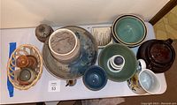 Overview of all pottery and ceramic items on a table, showing variety and condition