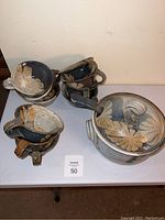 Pottery soup tureen with lid, 11 matching soup bowls stacked, and a ladle resting on top.