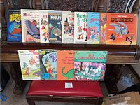 Overview of 13 vintage 1970s Walt Disney Disneyland vinyl albums lined up on a wooden shelf, showing colorful cover art including Dumbo and 101 Dalmatians.