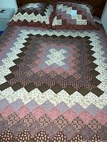 Full view of quilt spread on bed with two matching European shams