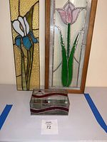 Two vertical stained glass panels and a decorative glass box on a flat surface with auction lot number visible.