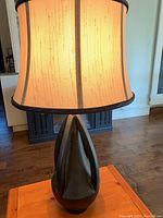 Close-up of the table lamp showing lamp shade and carved dark base
