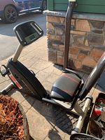 Side view of the HealthRider N35 stationary bike showing seat, frame, pedals, and base on outdoor pavement