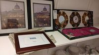 Two 8x10 wood frames with prints, 5x7 frame, and boxed pink mirrors and clock