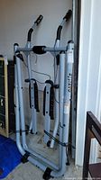 Front view of Tony Little Gazelle exercise machine showing frame, arm handles with foam grips, and arm support pads.