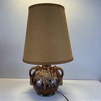 Table lamp fully assembled with brown woven fabric lamp shade.