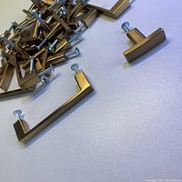 Photo showing champagne gold rectangular handles and matching cabinet pulls with screws.