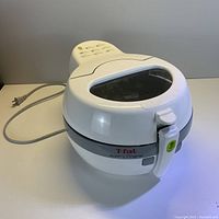 Front angle view of T-fal Actifry Original airfryer showing white body, transparent lid, and attached power cord.