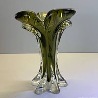 Front view of vintage art glass vase with green upper section and clear base, showing the flowing organic shape and feet detail.