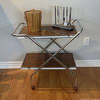 Front view of complete bar cart with wood veneer shelves and chrome frame