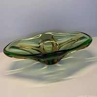 Wide angled photo of vintage green glass bowl showing the smooth curved body and solid base.