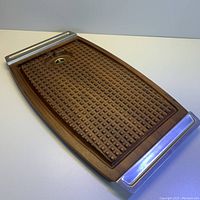 Full angled photo showing whole tray with steel handles and waffle-like textured pattern on walnut surface