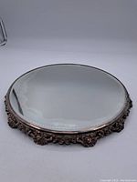 Top view of round antique pedestal mirror showing glass surface and metal frame