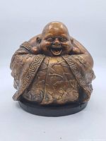 Front view of the Laughing Buddha statue showing full figure and detailed patterned draping.