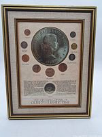 Full view of framed British coin collection featuring Queen Elizabeth II enlargement dated 1955, showing 10 coins arranged around central image with printed text.