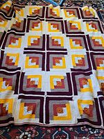 Full view of the handmade crocheted quilt displaying the full geometric pattern in multiple colors.