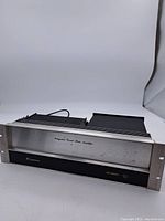 Front view of vintage Crown D150 amplifier showing metal panel with some spots and wear.