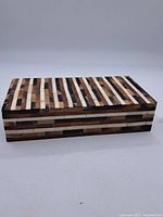 Full view of a rectangular wooden box featuring striped wood and stone inlay pattern on all visible surfaces.